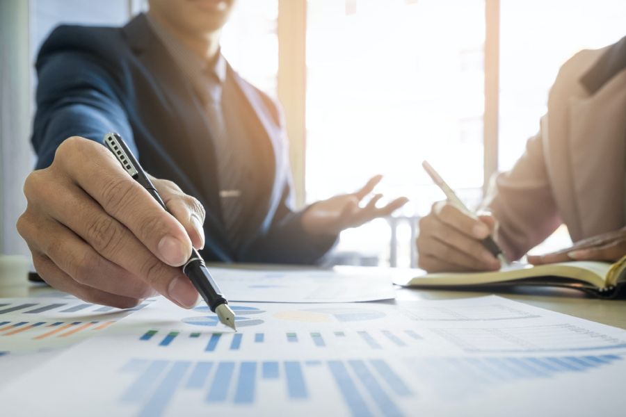 Dos personas discutiendo gráficos y apuntando datos